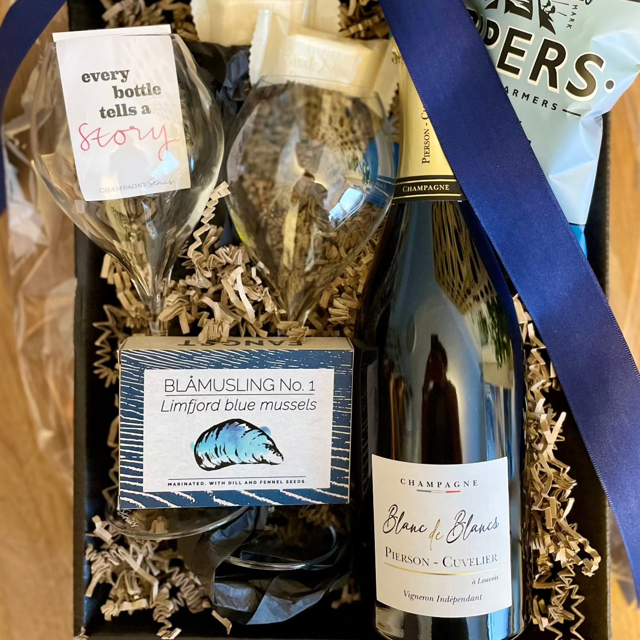 Gavekurv med 2 Lehmann Grand Jamesse champagneglas, 1 flaske champagne fra Champagne Pierson-Cuvelier, Blanc de Blancs, æske med blåmuslinger og andre lækkerier, blåt bånd