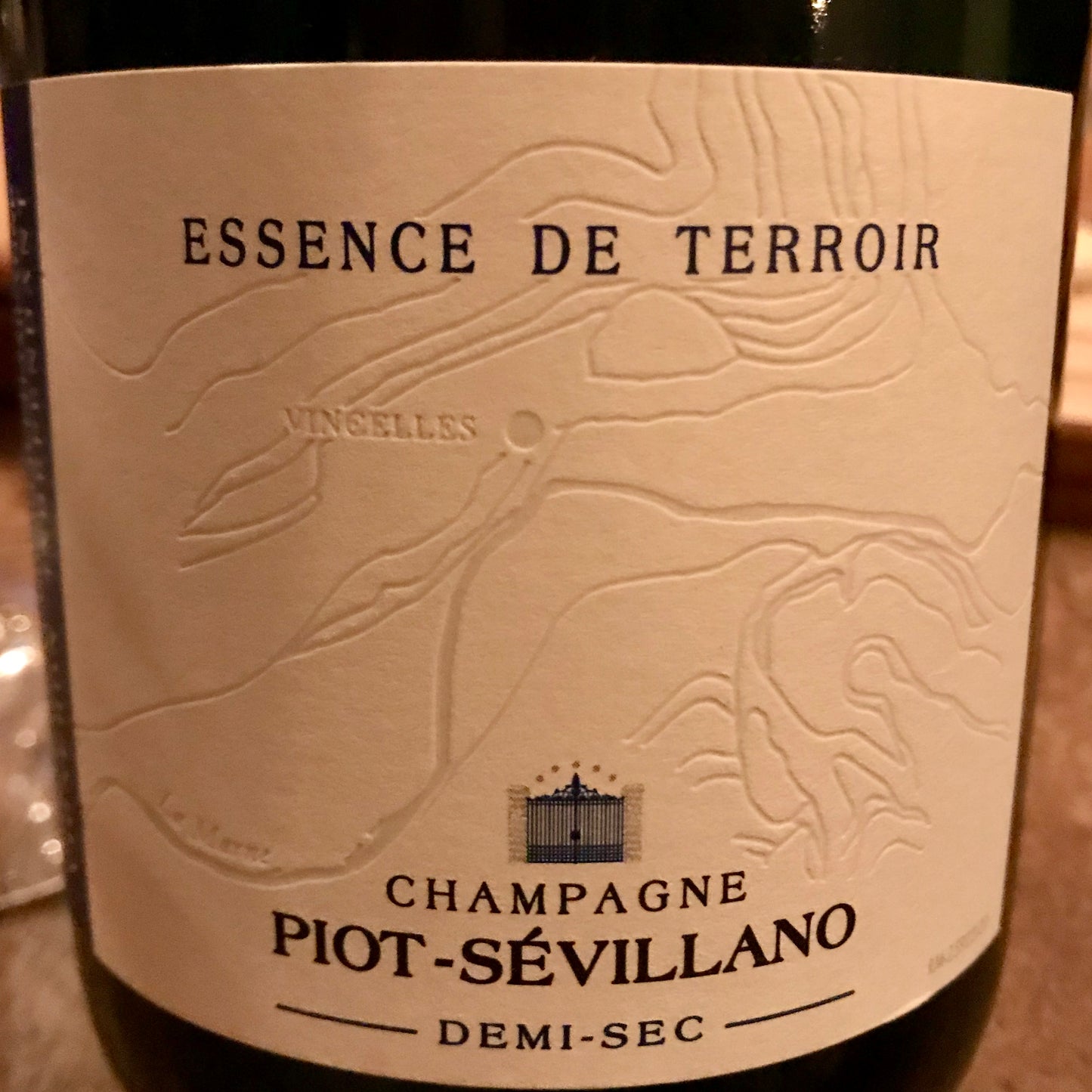 Tæt på etikette af champagne, Champagne Piot-Sévillano, Essence de Terrior, Demi-Sec, etiketten viser et kort over floden La Marne og byen Vincelles