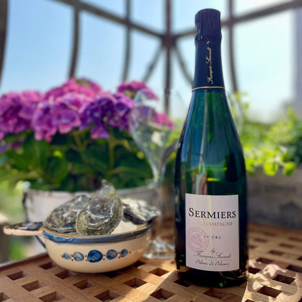 1 laske champagne på træbakke med østers og blomster i baggrunden, Francois Seconde champagne, Sermiers, Premier Cru champagne, Blanc de Noirs, Extra Brut