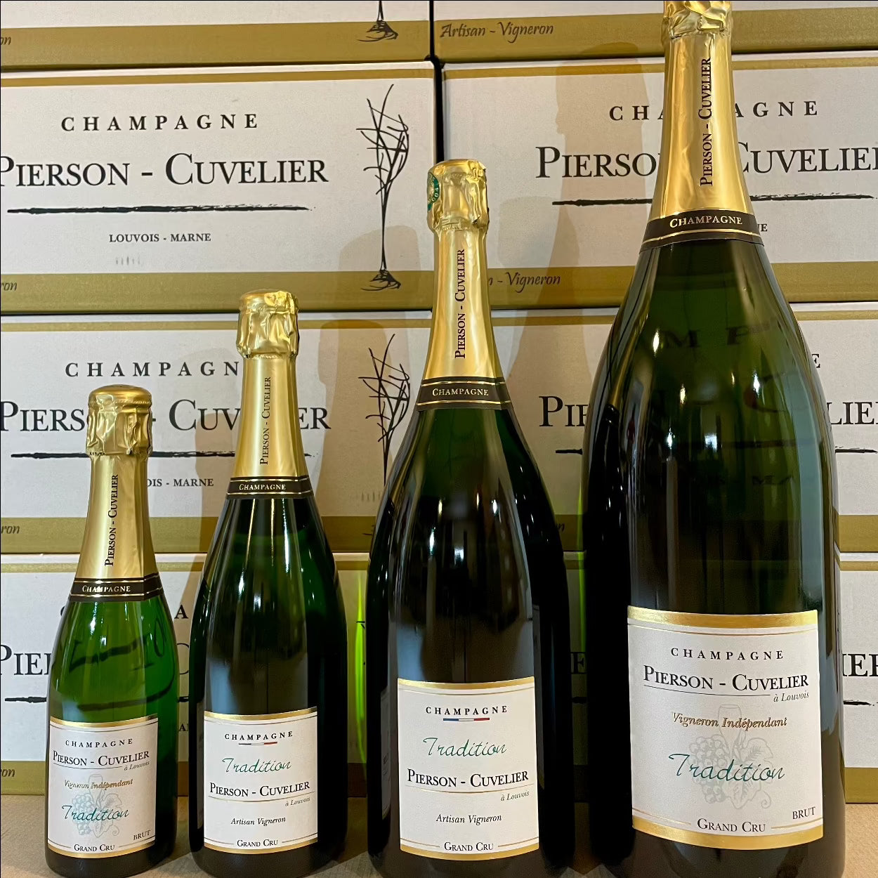 4 flasker champagne fra Champagne Pierson-Cuvelier, Tradition, Grand Cru, 4 forskellige størrelser flaske, 1/2 flaske 0,37 liter, normal flaske 0,75 liter, magnum flaske 1,5 liter, jerobaum 3 liter, baggrund vinkasser fra Pierson-Cuvelier med logo og navn