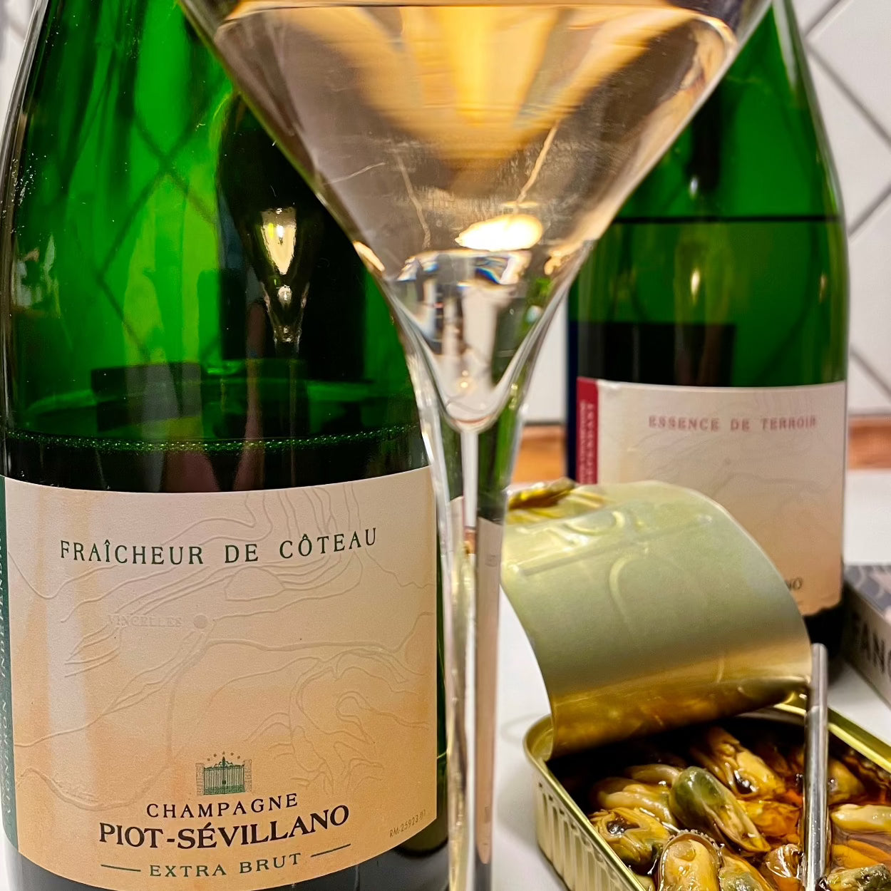 Champagne flasker på bord med et champagneglas tæt på,  muslinger i olie, Champagne Piot-Sévillano, Fraîcheur de Côteau Extra Brut