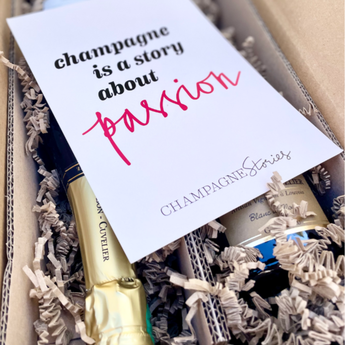 2 flasker champagne i forsendelseskasse med fnuller og et kort over flaskerne med teksten "champagne is a story about passion - Champagen Stories"