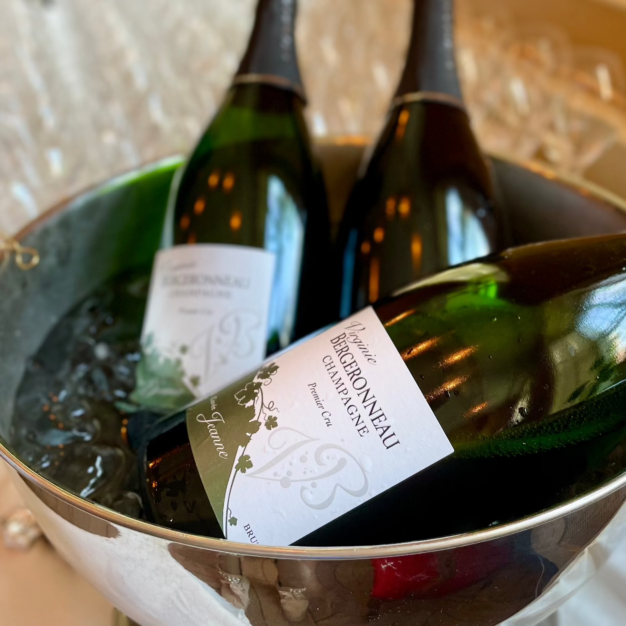 3 magnum flasker champagne fra Champagne Virginie Bergeronneau, Cuvée Jeanne i bowle og champagneglas uskarpt i baggrunden