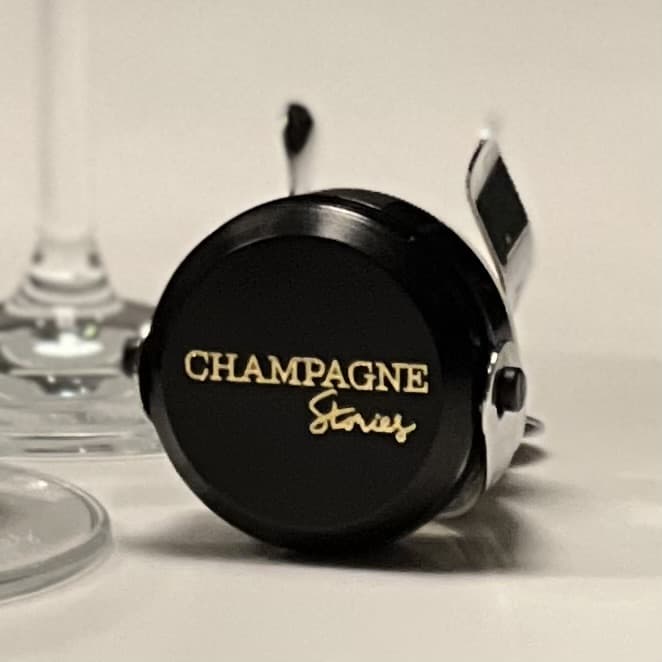 Champagnestopper, champagneprop, sort med logo påtrykt "Champagne Storoes"